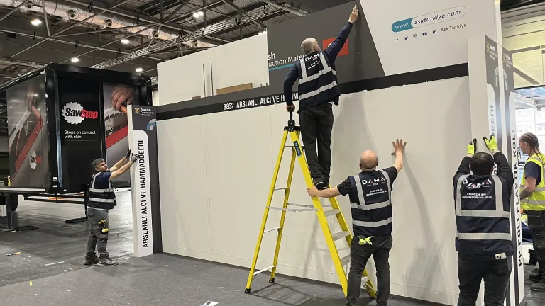 four men working on a white trade stand